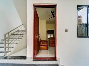 A staircase leading to a room with a wooden door, a ceiling fan, and a window. - Saver Double Pullans Arcade (Kanayannur)