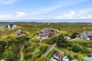 Un pueblo costero con casas tradicionales, cielo despejado y vista al mar.