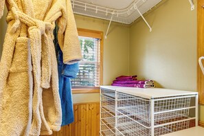 A room with a drying rack, a wooden floor, a window with blinds, and a white metal shelf with folded towels. - Tetonka Lake Views & Outdoor Entertainment Area! (Waterville)