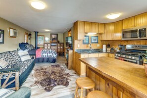 A cozy living room with a sofa, a rug, and a fireplace. - Tetonka Lake Views & Outdoor Entertainment Area! (Waterville)