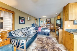 A cozy cabin interior with a sofa, a television, and a wooden cabinet. - Tetonka Lake Views & Outdoor Entertainment Area! (Waterville)