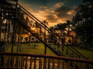 Un patio de hotel con escaleras, palmeras y vista al atardecer.