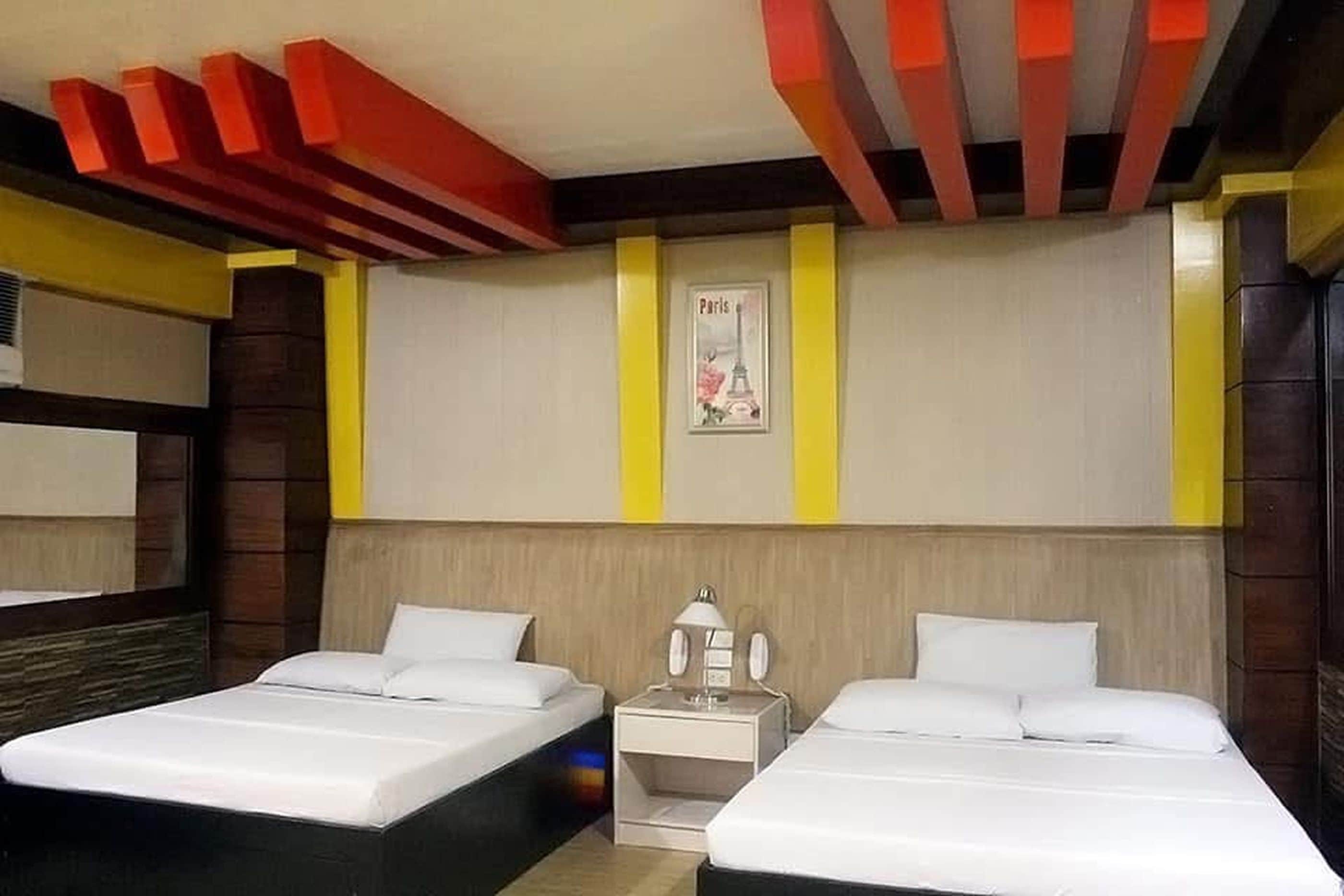 Habitación de hotel con dos camas, una mesita de noche y un cartel del Torre Eiffel.
