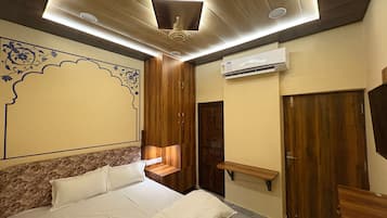 A bedroom with a bed, wooden wardrobe, and an air conditioning unit.