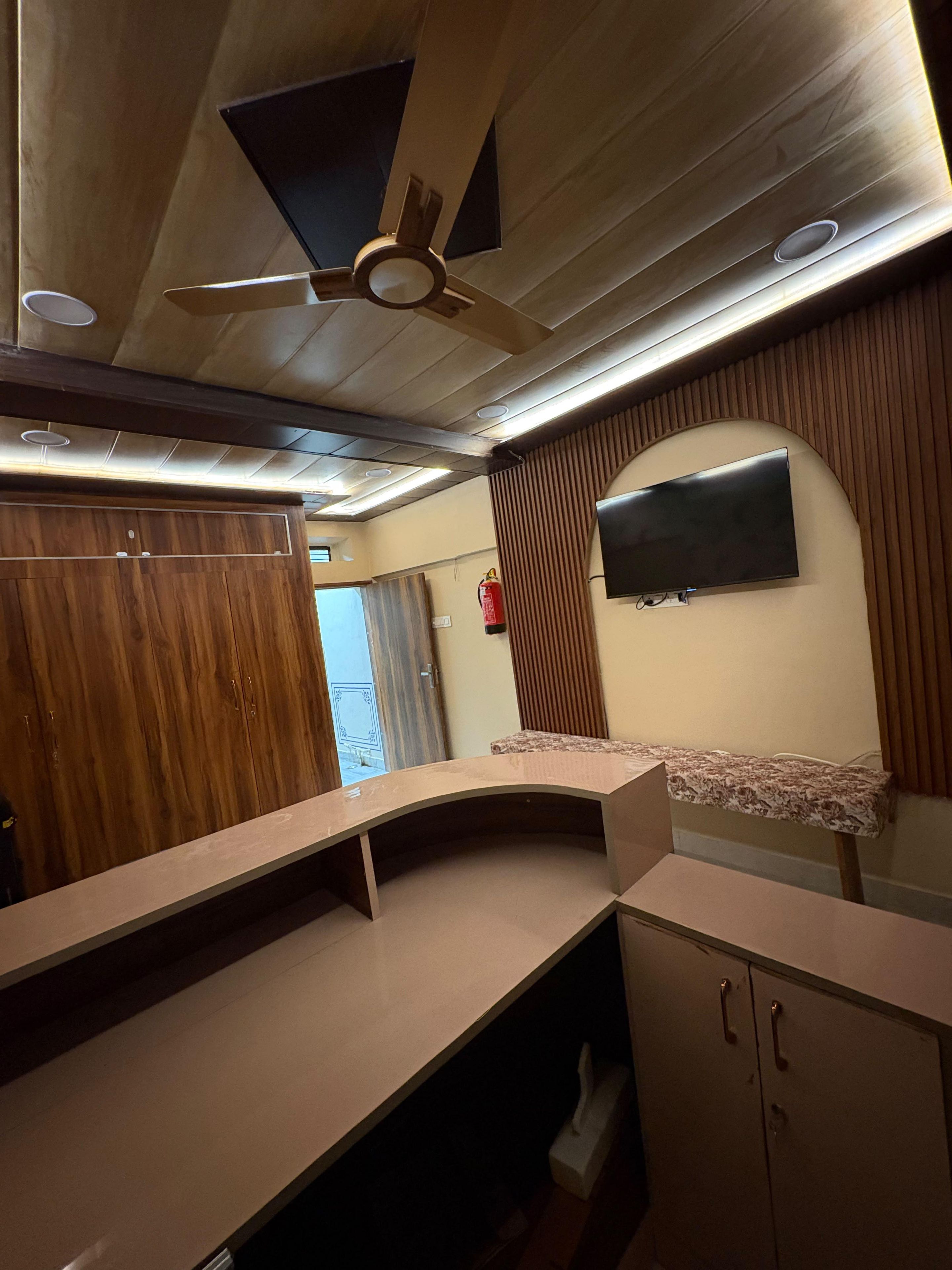 Una cocina moderna con armarios de madera, horno empotrado, microondas y ventilador de techo.