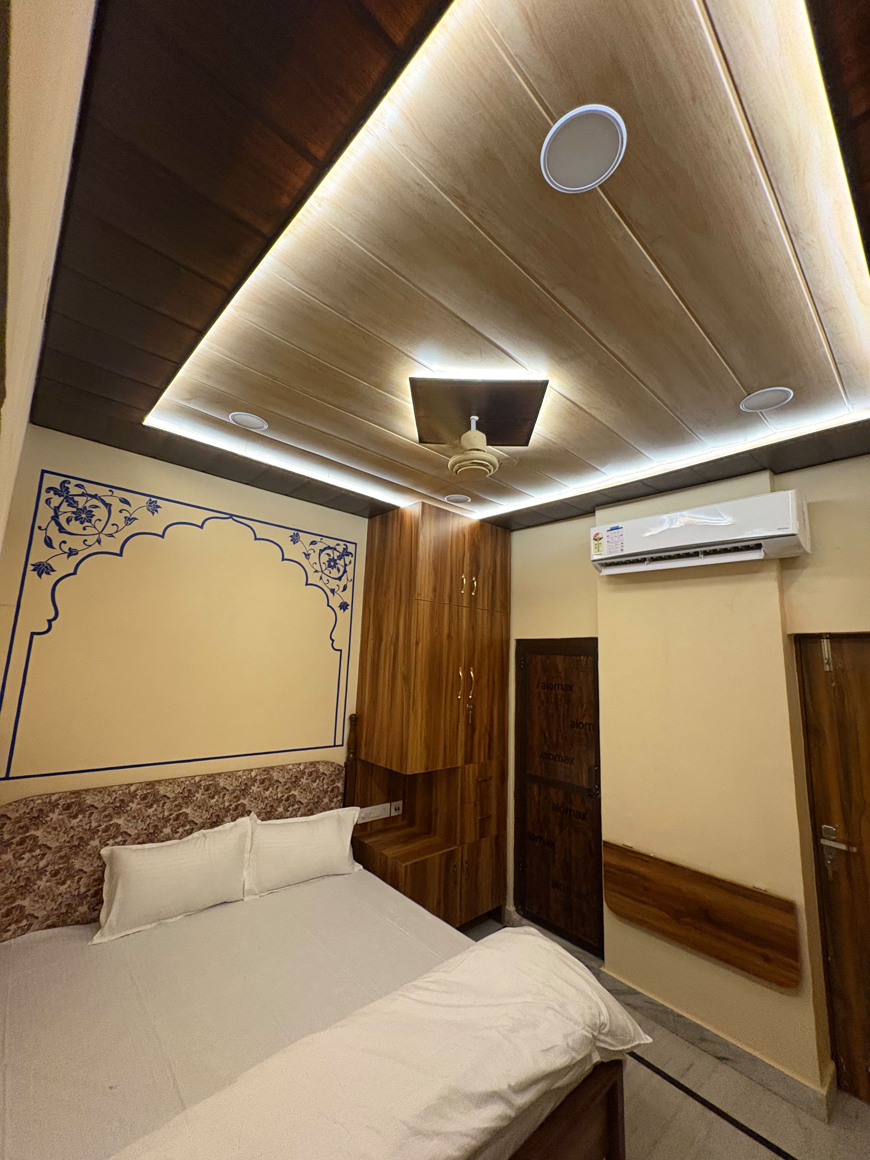Ein Schlafzimmer mit einem Bett, einem Holzschrank und einer Klimaanlage.