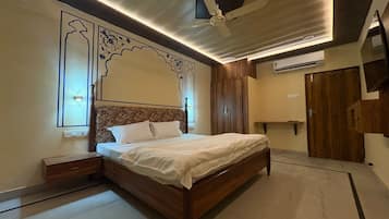 A bedroom with a bed, nightstands, a ceiling fan, and a wardrobe.