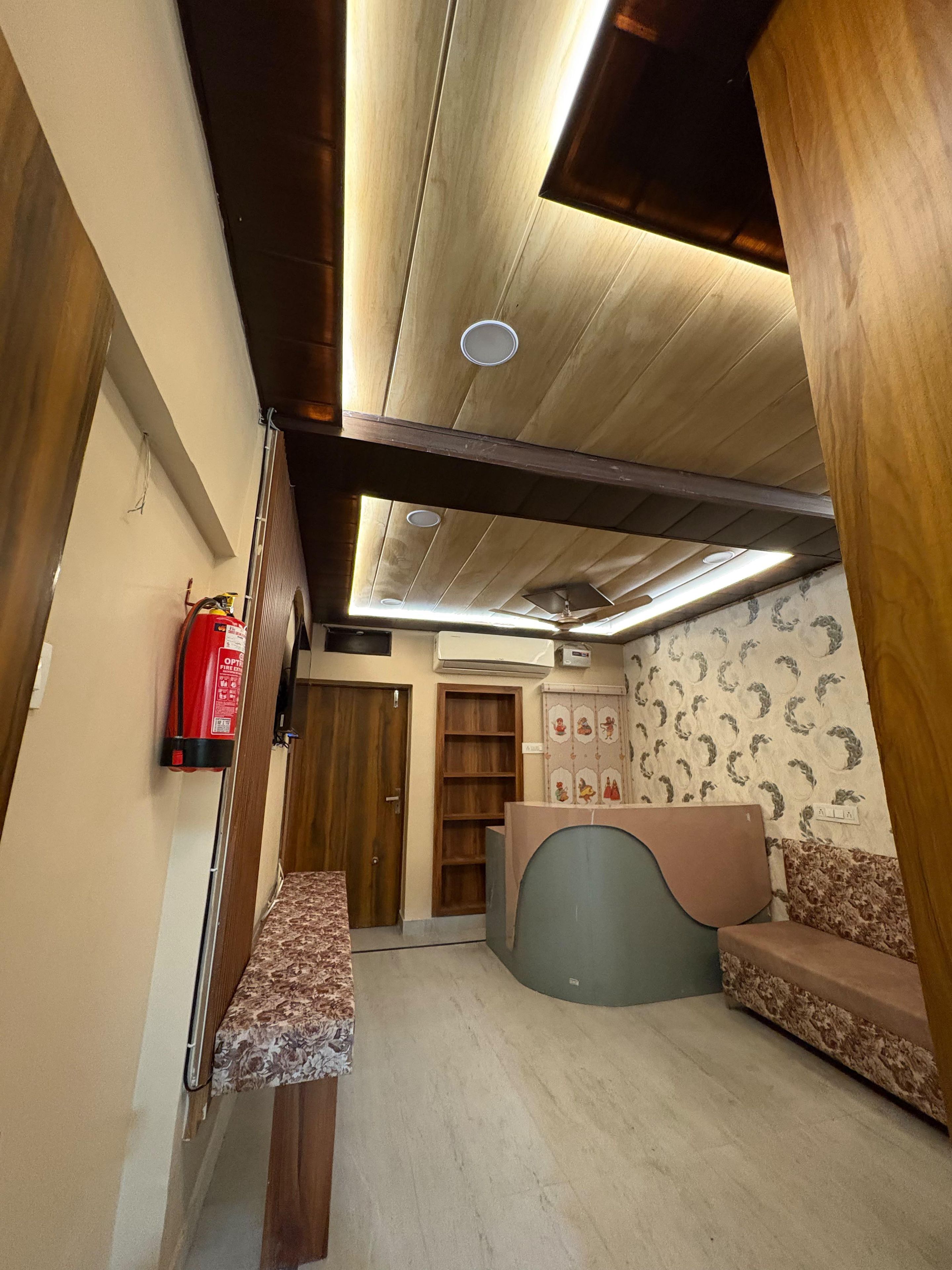 Una habitación con techo de madera, un extintor, una recepción y una pared con diseño.