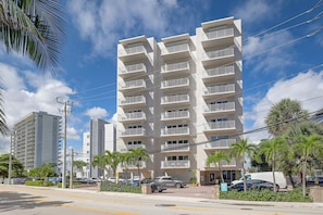 A multi-story residential building with balconies, a parking area, and palm trees. - 1 Block to Sand! Ocean-View Retreat w/ Pool Access (Fort Lauderdale)