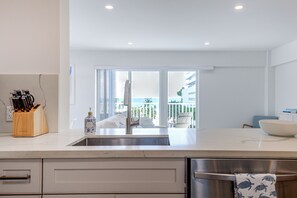 A modern kitchen with a large window, a sink, and a view of the sea. - 1 Block to Sand! Ocean-View Retreat w/ Pool Access (Fort Lauderdale)