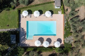 An aerial view of a rectangular swimming pool surrounded by a deck with multiple white umbrellas. - La Certaldina, Luna Apartment (Certaldo)