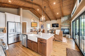A spacious kitchen with wooden cabinets, a stainless steel refrigerator, and a large island. - Luxe Couple's Cabin Retreat Outside Steamboat (Clark)