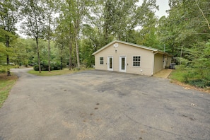 A single-story building with a garage, surrounded by dense trees. - Family Home < 1 Mi to Lake & Paris Landing! (Buchanan)