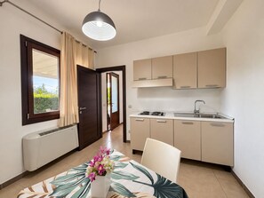 A compact kitchen with a dining area, a window with curtains, and a ceiling light fixture. - Apartment in Mazzarino with 1 bedrooms sleeps 2 (Mazzarino)