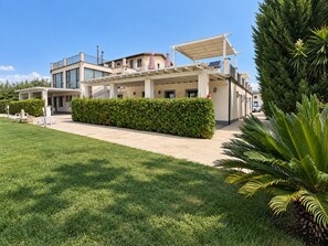 A modern building with a covered patio area, a well-maintained lawn, and a variety of greenery. - Apartment in Mazzarino with 1 bedrooms sleeps 2 (Mazzarino)