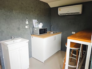 Cocina compacta con pileta, microondas y barra.