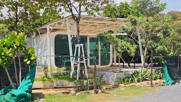 A covered outdoor area with a ladder, a table, and a bench.