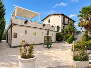 A courtyard with a building, a pergola, and a staircase leading to an upper level. - Vacation Home in Mazzarino with 1 bedrooms sleeps 2 (Mazzarino)