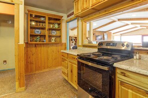 A kitchen with wooden cabinets, a stove, and a countertop. - ATV Adventures & Private Pond! Marysvale Retreat (Marysvale)