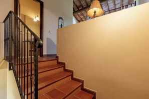 A staircase with a wooden handrail and a wall with a textured finish. - La Certaldina, Stella Apartment (Certaldo)