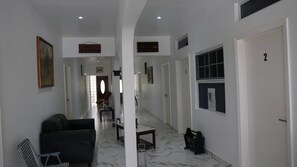 Um corredor com um sofá, uma mesa e uma porta marcada com o número 2.