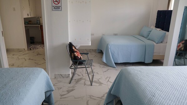 A hotel room with two beds, a chair, a small table, and a sign prohibiting smoking. - Complete Property Rental – Private & Comfortable (Clarendon Park)
