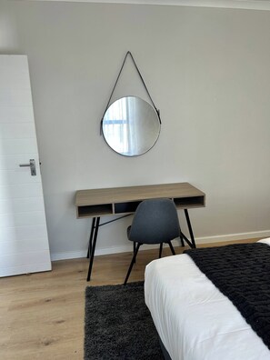 Une chambre à coucher avec un lit, un bureau et une chaise.