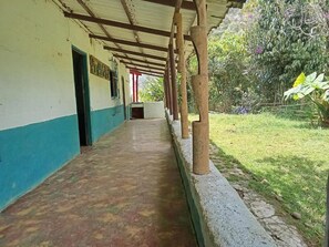 Un pasillo cubierto con piso de concreto que conduce a la entrada de un edificio.