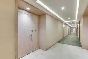 A hotel corridor with a carpeted floor, wooden doors, and recessed lighting. - Beach + Poolside Days! Extended Coronado Escape (Coronado)