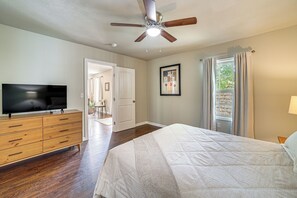 A bedroom with a bed, a dresser, a television, a ceiling fan, and a window with curtains. - Private Workout Studio & Fenced Yard! Tulsa Escape (Tulsa)