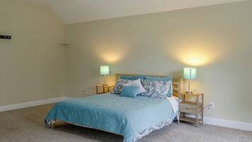 A bedroom with a bed, two bedside lamps, and a carpeted floor.