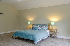 Ein Schlafzimmer mit einem Bett, zwei Nachttischlampen und Teppichboden.