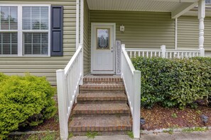 A house with a front porch, a door with a glass panel, and a sign that reads 'BLESSED'.