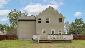 A two-story house with a front porch and a fenced yard.