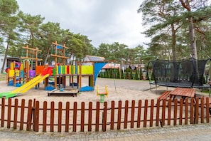 A playground with various play structures, a trampoline, and a picnic table. - Holiday home with 2 bedrooms (Dzwirzyno)
