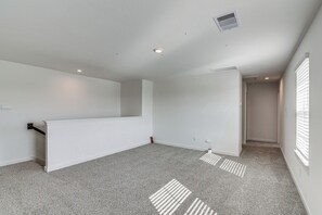 A room with a sloped ceiling, recessed lighting, a radiator, and a window with blinds. - Modern Fresno Home w/ Yard: Near Parks & Shopping (Fresno)