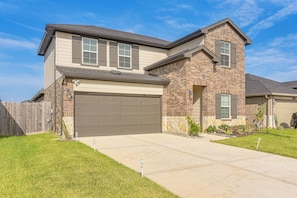 A two-story house with a garage, a stone foundation, and a well-maintained lawn. - Modern Fresno Home w/ Yard: Near Parks & Shopping (Fresno)