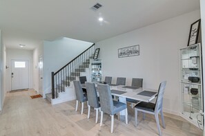 Un espace repas comprenant une table et des chaises, un escalier et une vitrine.