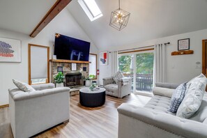 A spacious living room with a fireplace, a television, and a balcony with outdoor furniture. - 4 Mi to Big Boulder! Pocono Family Retreat (Blakeslee)