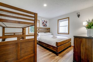 A bedroom with a bunk bed, a single bed, a bedside table, a potted plant, and a window with blinds. - 4 Mi to Big Boulder! Pocono Family Retreat (Blakeslee)