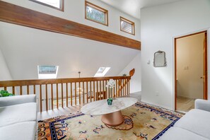 A spacious room with a high ceiling, a wooden staircase, a round marble table, and a patterned rug. - 4 Mi to Big Boulder! Pocono Family Retreat (Blakeslee)