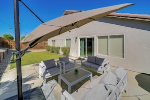 A patio with outdoor furniture, a pergola, and a house with a light-colored exterior. - Coachella Getaway w/ Yard! Near Festivals & Golf (Coachella)
