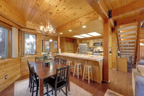 L’intérieur d’une cabane en bois comprend un coin repas, une cuisine et un escalier.