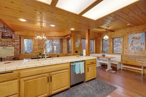 Ein Holzhaus-Innenraum mit Küche, Essbereich und Kamin.