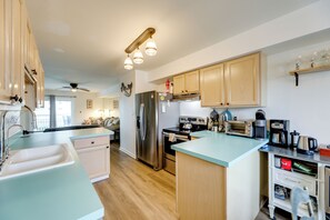 Une cuisine moderne avec des meubles en bois, des appareils en acier inoxydable et un plan de travail bleu clair.