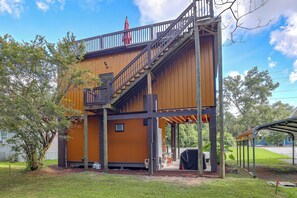 A two-story building with a wooden exterior, a staircase, and a covered outdoor area. - Blue n Hall Fish House, Steps From the Marina! (Darien)