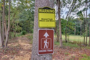 A warning sign for a shared hiking trail with a hiking symbol.