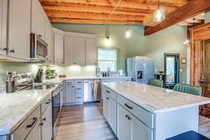 A modern kitchen with white cabinetry, stainless steel appliances, and a wooden ceiling. - Peaceful Cabin on Pond w/ Hot Tub & More! (Lookout Mountain)