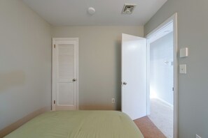 A bedroom with a bed, a closed door, and a wall-mounted light fixture. - Screened Porch & Steps to Lake! Pocono Summit Home (Pocono Summit)
