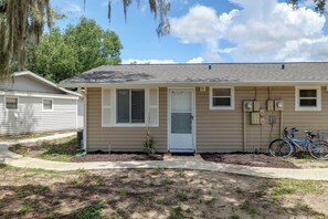 A single-story house with a front door, a small porch, and a bicycle parked outside. - The Wandering Parrot: Pool, Pickleball & Lake (Clermont)